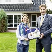 ein mann und eine frau stehen auf einer wiese vor einem haus