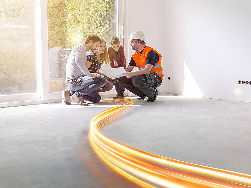 vier personen in hocke betrachten einen plan