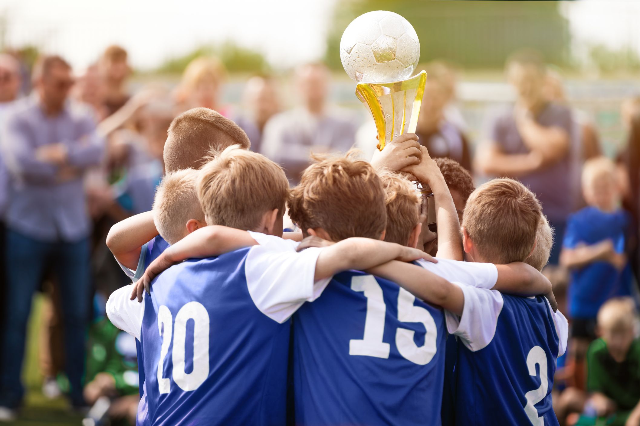 vier Kinder in blauen fußball trikots und einem fußball