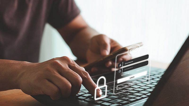 ein mann sitzt an einem laptop und tippt etwas auf der tastatur