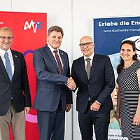4 personen bei einerm foto und einem handshake