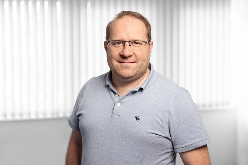 Das Bild zeigt einen Mann, der in die Kamera lächelt.