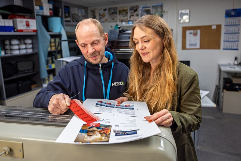 Zwei Männer, Martin Runge und Lucas Eib, sitzen an einem Tisch mit zwei Laptops und unterhalten sich.